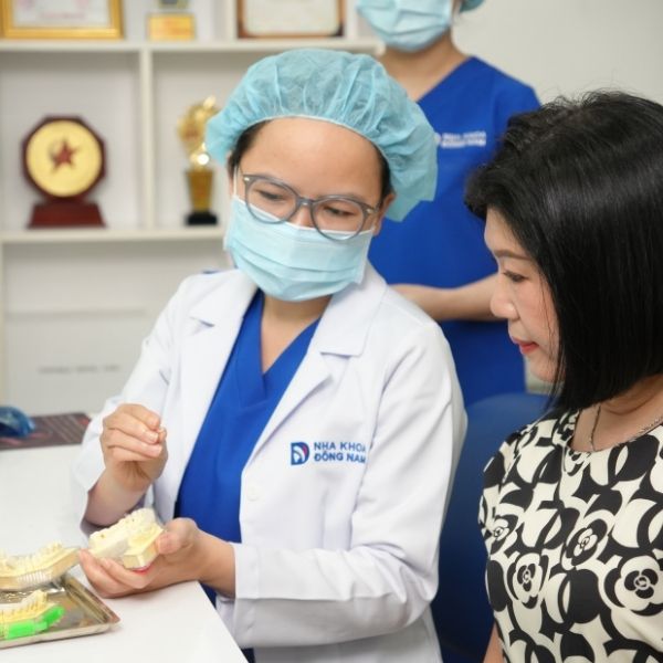 Bác sĩ Nha Khoa Đông Nam tư vấn và giới thiệu mẫu cầu răng sứ cho khách hàng